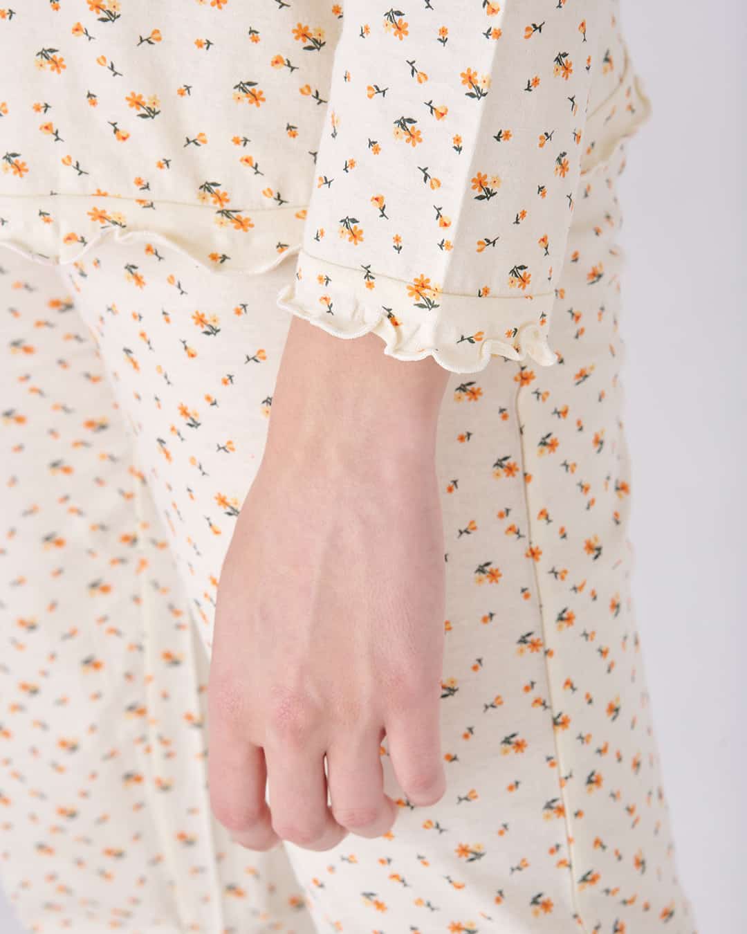 Dettaglio manica del pigiama aperto lungo da donna con fiorellini e fiocco